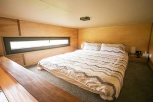 una camera da letto con un letto grande in una stanza di Tiny Cradle at The Good Place a Staverton