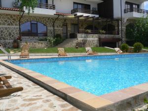 a swimming pool in front of a building at Madara Club and Spa in Kosharitsa