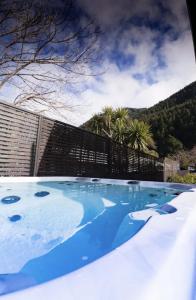 a plunge pool with blue water in a backyard at CLASSY CABIN - IN TOWN - SPA POOL in Queenstown