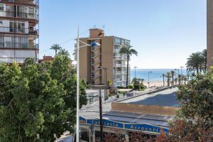 a view of a beach with a building and the ocean at Aparmento Eolo in Benidorm
