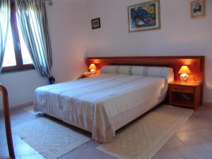 1 dormitorio con 1 cama y 2 lámparas en las mesas en Il Gabbiano, en Chia
