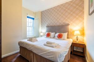 a bedroom with a large bed with two towels on it at Tron Kirk Residence in Edinburgh