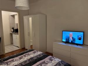 1 dormitorio con cama y vestidor con TV de pantalla plana. en Gare-30A-3, en Lausana