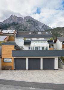 a house with a garage with mountains in the background at Apartment Enarina in Telfs in Telfs