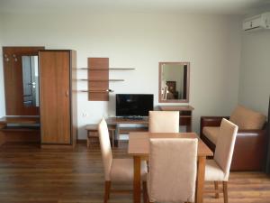a dining room with a table and chairs and a television at Madara Club and Spa in Kosharitsa