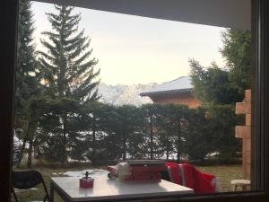 a window with a table and a view of a mountain at Grain d'Or - Studio 008 in Verbier