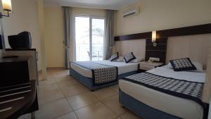 a hotel room with two beds and a television at Kleopatra Balik Hotel in Alanya