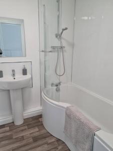 a white bathroom with a tub and a sink at The Selbourne Hotel in Scarborough
