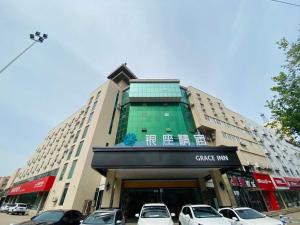 a large building with cars parked in front of it at 银座精宿(黄岛金沙滩香江路商业街店) in Qingdao