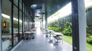 馬塔蘭的住宿－Prime Park Hotel & Convention Lombok，植物丛中的一排桌椅