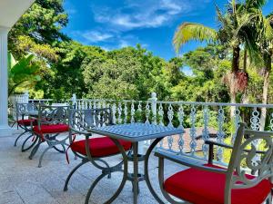 a row of chairs and a table on a balcony at The Whitehouse Bed and Breakfast in Durban