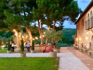 un grupo de personas de pie fuera de un edificio con luces en Wine Resort Conti di San Bonifacio, en Montemassi