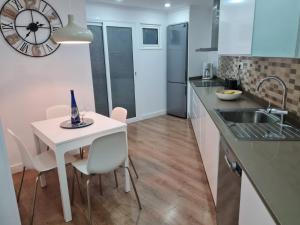 a kitchen with a white table and chairs and a sink at Your Canary Home in Las Palmas de Gran Canaria