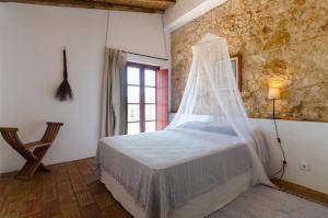 sypialnia z łóżkiem z moskitierą w obiekcie Casas na Vinha - Monte da Casteleja, Wine Estate - Eco Turismo Rural w Lagosie