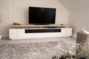 una sala de estar con TV en un centro de entretenimiento blanco en Ferienwohnung Leonie nahe Detmold Zentrum, en Detmold