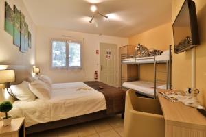 a bedroom with two bunk beds and a desk at Les Arbousiers Village Hôtel Provençal in La Roquebrussanne