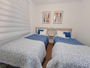 two beds in a room with blue and white sheets at Your Canary Home in Las Palmas de Gran Canaria