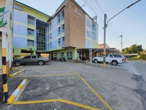 a parking lot with cars parked in front of a building at Chonnatee Residence in Chum Phae