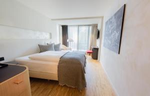 um quarto de hotel com uma cama e uma janela em Hotel Heiden - Wellness am Bodensee em Heiden