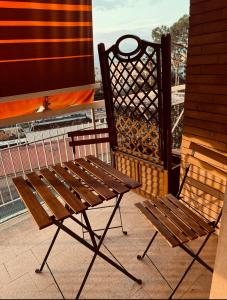 eine Holzbank und ein Stuhl auf dem Balkon in der Unterkunft Very House in Sorrent