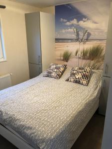 a bedroom with a bed with a view of the beach at Chalet Zeekraal in Buren