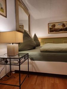 um quarto com uma cama e uma mesa com um candeeiro em Ferienwohnung "Wiesensee" im historischen Landhaus em Pottum