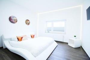 ein weißes Schlafzimmer mit einem weißen Bett und einem Fenster in der Unterkunft SECRET HIDEAWAYS Space Loft Wohndesign auf 2 Etagen l 450m bis Uni in Duisburg