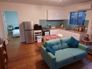 a living room with a blue couch in a kitchen at Modern & Light CBD unit, walk to beaches & cafes in Newcastle