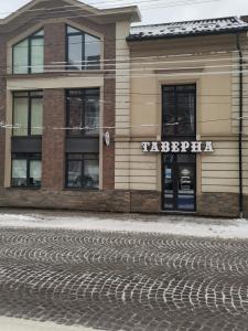 a building with a sign on the side of a street at Капрі in Mukacheve