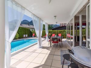 une terrasse avec une piscine, une table et des chaises dans l'établissement Landhaus Central, à Söll