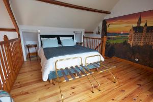 a bedroom with a bed with a painting on the wall at Normand'Histoire Gite 1869 in Isigny-sur-Mer