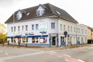 a white building on the corner of a street at Hotel-Restaurant Fück in Leverkusen