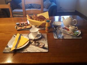 una mesa con un plato de comida y una cesta de pan en Rose de la Mer, en Hirel