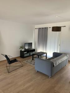 a living room with a couch and a chair at Grande maison neuve idéale pour 6 personnes in Saint-Loubès