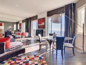 een woonkamer met een tafel en stoelen en een bank bij Un Palais au prix d'un 3 étoiles in Cannes
