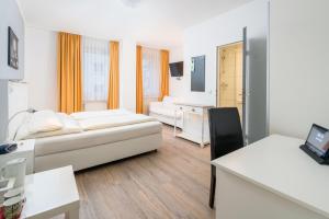ein Hotelzimmer mit einem Bett und einem Schreibtisch in der Unterkunft Stadt-gut-Hotel Rheinischer Hof in Essen