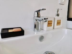ein Waschbecken mit einem Chrom-Wasserhahn und zwei Kerzen in der Unterkunft COC - Le Phare in Wissant