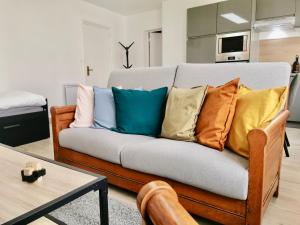 ein Sofa mit bunten Kissen darauf im Wohnzimmer in der Unterkunft COC - Le Phare in Wissant