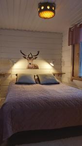 a bedroom with a bed with a deer head above it at Vuosselin Tähti in Ruka
