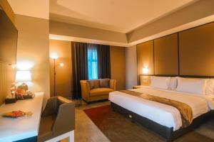a hotel room with a bed and a chair at BeSS Mansion Hotel Surabaya in Wonocolo +56 photos