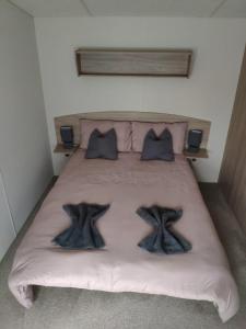 ein Schlafzimmer mit einem Bett mit zwei Meerjungfrauenkissen in der Unterkunft Lovely Static 8 Bed Caravanat at Billing Aquadrome in Great Billing