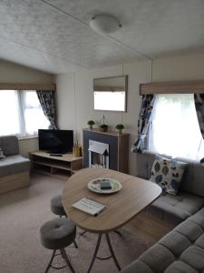 a living room with a table and a couch at Lovely Static 8 Bed Caravanat at Billing Aquadrome in Great Billing