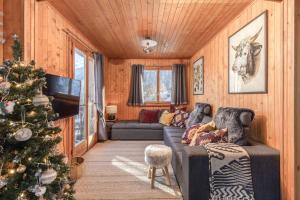 una sala de estar con un árbol de Navidad y un sofá en Chalet Noisette Authentic Swiss chalet Perfect for families, en Riddes