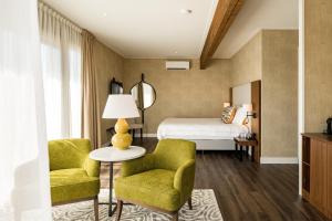 1 Schlafzimmer mit einem Bett, 2 Stühlen und einem Tisch in der Unterkunft Hotel Ter Zand - Handwritten Collection in Burgh Haamstede + 37 Fotos