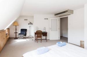 a bedroom with a bed and a desk and a chair at Penthouse -By the Danube in Budapest