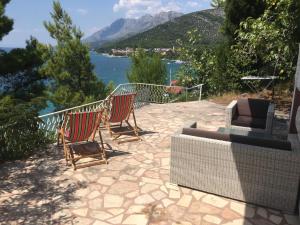 two chairs and a television on a patio with a view of the water at Apartment Marevista in Zaostrog