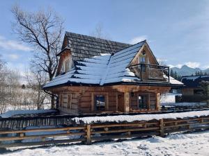 a log cabin with snow on the roof at Domek Góralski- Highlander Chalet Kościelisko-Zakopane in Kościelisko