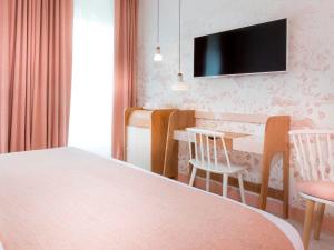 a bedroom with a bed and a table and chairs at Hotel le Lapin Blanc in Paris