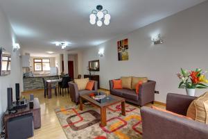 a living room with couches and a tv at Fenesi Gardens Apartments in Nairobi