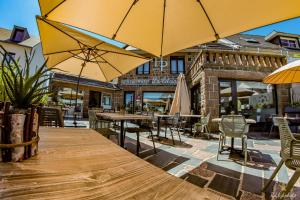 an outdoor patio with tables and chairs and umbrellas at Logis Hôtel du Parc in Perros-Guirec